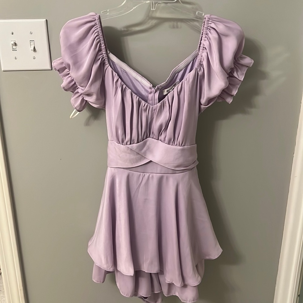 Short lilac dress with puffy sleeves and bow that ties in the back.